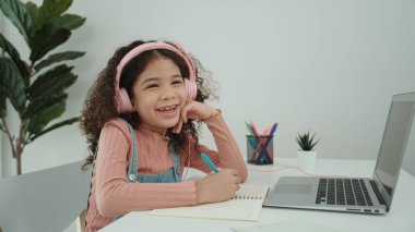 Akıllı bir kızın kulaklığını çıkartıp, ödevlerini yaparken yan bakış açısı. Programlama sistemini araştırırken ve mühendislik komut yazarken deftere yazı yazan beyaz bir kız öğrenci. Pedagoji.