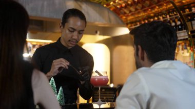 Karışık kokteyl Noel temasına odaklanarak yanan tarçın ve barmenin yıldız anasonuyla süslenmiş yeşil neon karlı Noel ağacı çikolatası özel serin içecek lüksüyle süslenmiş. Vinosity.