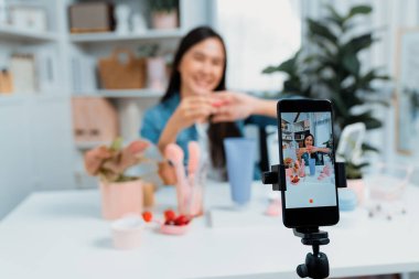 Kozmetik makyaj makyajı, ruj, pastel renkler, sosyal medyada kol testi promosyonunda en çok satan kitaplar koleksiyonunu gösteren seçici odaklı telefon. Taktik.