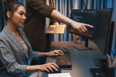 Modern ofisteki neon ışık odasında bilgi ağını gösteren dizüstü bilgisayarla iki ekranda veri çalıştıran akıllı web sitesi geliştirme kodlayıcı sistemini tartışan IT geliştiricilerinin ciddiyeti. İnfobahn.