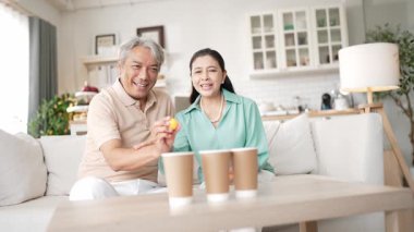 Mutlu yaşlı çift evde birlikte top atmaktan zevk alıyor, sağlıklı yaşlanma için koordinasyon ve bilişsel beceriler geliştiriyorlar. Büyükbabam ve büyükannem klozete pinpon oynuyorlar. Myrmidon.