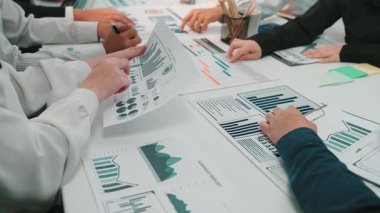 Profesyonellerden oluşan çeşitli bir ekip, veri güdümlü kararlar için planlar ve grafikleri analiz ederek, işbirliği ve stratejik planlama sergiliyor. SACTR