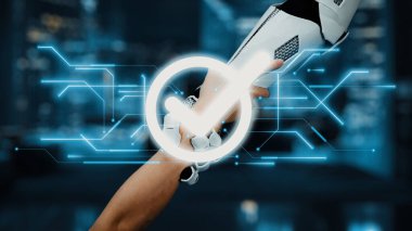 Teknoloji ve insanlık arasındaki uyumu temsil eden, dijital bir işaretle vurgulanmış, insan koluyla tokalaşan robotik bir kolu gösteren fütüristik bir sahne. Auvana