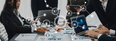 Modern bir ofiste birlikte çalışan profesyoneller, verileri analiz ediyor ve etkin karar verme mekanizmaları için teknoloji ve dijital araçlar kullanarak iş stratejileri geliştiriyorlar. Dostluk