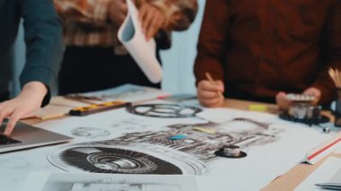 Dinamik bir ekip, teknik çizimleri analiz ederek ve dijital cihazları modern ofis ortamında kullanarak, yenilik ve takım çalışmasını somutlaştırarak bir mühendislik projesinde işbirliği yapıyor. SACTR