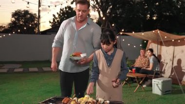 Aile birlikte bahçede kamp kurar, baba ve kız aile bireyleri için ızgara yapar. Doğayla iç içe olmak için açık hava kamp aktiviteleri ve genç nesil çapraz kuşaklarla zaman geçirmek için. Uyumsuzluk.