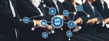 Takım elbiseli profesyonelleri yönetim ve takım çalışmasının kilit yönlerini sembolize eden grafik simgelerle çevrili bir iş konferansında gösteren dinamik bir sahne. Dostluk