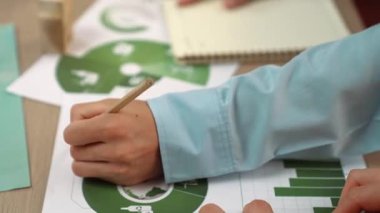 Mükemmel iş adamları, yeşil enerji grafiği kullanımı olan karmaşık bir masada eko ev projesini tartışıyor alternatif enerjiyi seçiyor ya da analiz ediyor, karbonu azaltıp dünyayı kurtarıyor. Eline odaklan. Tanımlama.