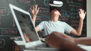 Kara tahtadaki Afrikalı öğrenci el kodlaması ya da programlama sisteminin web geliştirme planıyla kapatılması. Bu arada genç bir kız da mühendislik dersiyle kara tahtada oynuyor. Yenilik. Öğretim