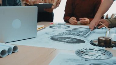 Dinamik bir ekip, teknik çizimler ve dizüstü bilgisayarın yer aldığı, yaratıcılık ve takım çalışmasını ön plana çıkaran modern bir ofiste bir mühendislik projesi üzerinde işbirliği yapıyor. SACTR