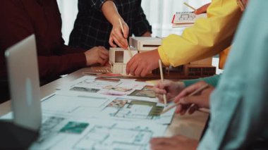 Çeşitli mimarlardan oluşan bir grup, modern ofis ortamında takım çalışması ve yaratıcılığı sergileyen tasarım konseptleri ve taslakları hakkında bizzat tartışır. SACTR