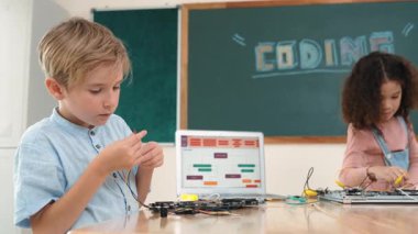 Dizüstü bilgisayar ekranında çalışan çeşitli öğrenci kodlama mühendisliği komut yazılımı ve yapay zeka programlaması yapıyor. Amerikalı kız, erkek makine tamir ederken ekipmanları teftiş ediyor. Pedagoji.