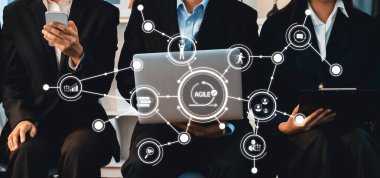 Profesyonel bir ekip, çevik proje yönetimi ve etkili iletişim stratejileri için dijital cihazlardan yararlanarak modern bir ofis içinde işbirliği içine girer. Dostluk