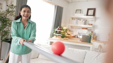 Büyükannenin elinde boru var ve göz, el koordinasyonunu geliştirmek ya da odaklanma ve konsantrasyonu arttırmak için top yuvarlama oyunu oynuyor. Yaşlı çift stresi azaltıyor. Sağlık hizmetleri. Myrmidon.