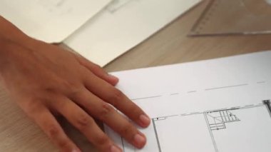 Ölçüm ve yazma aracını kullanarak mimari ofisindeki inşaat doğruluğu için ayrıntılı bir plan tasarlayan akıllı mimar ya da akıllı mühendisin videosu. Eline odaklan. - Yakın çekim. Tanımlama.