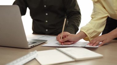 Mimar ve mühendis, modern ofisteki tablo üzerinde tasarım, ölçüm aracı ve plan için dizüstü bilgisayardaki taslak ayrıntılı taslak ile el yazısını karşılaştırıyor. - Yakın çekim. Tanımlama.