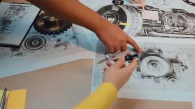 Bu resim, mekanik tasarım projesinin planlanmasında aktif olarak yer alan, teknik çizimler ve çalışma alanındaki karmaşık ekipman bileşenlerini ele alır. SACTR