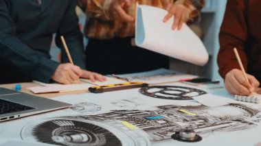 Bir uçak motoru tasarımı projesinde çalışan mühendislerden oluşan bir ekip, yenilikçi bir çalışma alanında modern bir dizüstü bilgisayarla teknik çizimleri analiz ediyor. SACTR