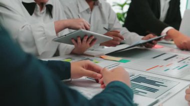 Bir iş ekibi stratejik bir toplantıya katılır, verileri analiz eder ve dijital cihazlar ve grafiklerle modern ofis ortamında fikirleri ortaklaşa tartışır. SACTR