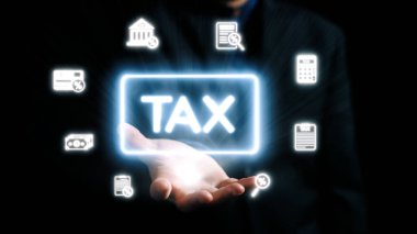 Profesyonel bir elde, modern vergi yönetimi ve istişare yaklaşımlarını vurgulayarak çeşitli mali hizmetleri temsil eden dijital simgelerle çevrili parlak bir vergi sembolü sergileniyor. Dörtgen