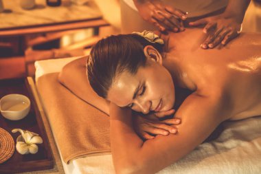 Beyaz kadın müşteri stres önleyici spa masajının keyfini çıkarıyor ve lüks otel ya da otelde sıcak mum ışığında güzellik teniyle eğleniyor. Sessiz.