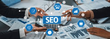 Profesyonel bir iş ekibi, dijital pazarlama etkinliği ve büyümeyi artırmak için veri analizi ve tartışmadan yararlanarak çağdaş bir ofiste SEO stratejisi üzerinde işbirliği yapmaktadır. Dostluk