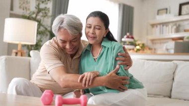 Büyükannem dambılı tutarken karısını cesaretlendiriyor ve ona sarılıyordu. Yaşlı çift, esnekliği arttırmak ya da kardiyovasküler gelişimi sağlamak için halter egzersizi yapıyor. Koruyucu sağlık hizmeti. Myrmidon.