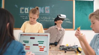 VR kulaklık takan enerjik bir çocuk sınıfta sanal dünyaya giriyor. Öğrenci programlama sistemi, çocuk elektronik panoyu tamir ederken yapay zeka ile mühendislik komut yazılımı oluşturdu. Pedagoji.