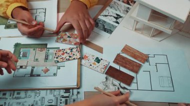 Mimari planlarla birlikte malzeme örneklerini inceleyen, iç tasarım ve yenileme projelerinin yaratıcı sürecini gösteren canlı bir çalışma alanı. SACTR