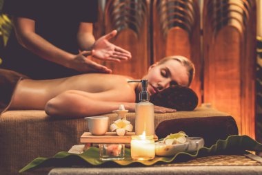 Aromaterapi masajı ambiyansı ya da spa salonu kompozisyon düzeneği bulanık kadınlara odaklı dekor mumları ve spa aksesuarları ile tatil köyü veya otel arka planında keyifli aroma spa masajı yapan. Sessiz.