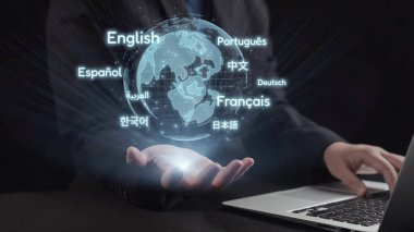 Bir iş adamı, çeşitli dilleri gösteren, çeviri ve öğrenme için teknolojinin ve küresel iletişimin füzyonunu temsil eden holografik bir küreyle etkileşim içindedir. Dörtgen