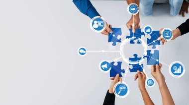İş büyümesi için dijital pazarlama güdümlü stratejilerdeki takım çalışmasını sembolize etmek için çeşitli ellerin bulmaca parçaları birleştirdiği işbirlikçi bir sahne keşfedin. Dostluk