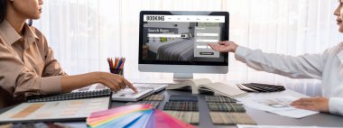 Masadaki bir grup iç mimar takımı dizüstü bilgisayarında mimari yazılım bulunan çeşitli ruh hali tahtası örneklerini seçiyor. Modern yenileme ve iç malzeme seçimi konsepti. İçgörü