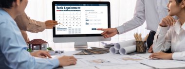 İç mimar tasarımcı grubu, daha kesin tasarım için planlar ve dizüstü bilgisayar ekran mimari yazılımı üzerinde birlikte tartışıyorlar. Modern ev tasarımı ve yenileme. İçgörü