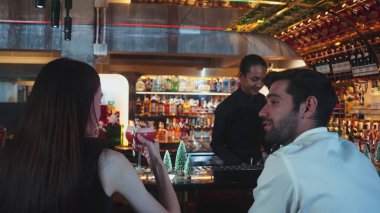 Barmen kokteyl temalı karışık kokteyl servis ediyor. Karışık kokteyl temalı. Karışık kokteyl çubuğuyla süslenmiş yeşil neon karlı Noel ağacında içki içen bir kadına servis ediliyor. Vinosity.