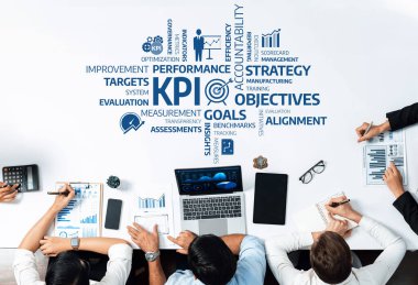 Çeşitli bir iş ekibi KPI 'ler, stratejiler ve performans ölçümlerine odaklanan bir masa etrafında işbirliği yapar. Çizelgeler ve araçlar gelişim ve başarı için tartışmaları kolaylaştırır. Dostluk