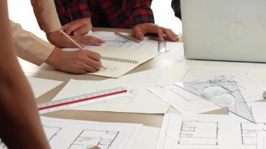 Mimarlık ve güvenlik mühendisi, modern ofiste dizüstü bilgisayarda mimari belge ve ahşap blokla sergilenen planlar hakkında tartıştı. - Yakın çekim. Tanımlama.