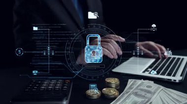 Bir iş adamı, para ve sikkelerle çevrili bir dizüstü bilgisayardaki mali verileri güncelleyerek, modern finans ve dijital işlemlerdeki teknolojik rolü vurguluyor. Dörtgen