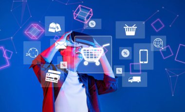 Yenilikçi bir alışveriş deneyimi için sanal gerçeklik teknolojisini kullanan genç bir birey, dijital araçların modern perakende ortamlarına entegrasyonunu sergiliyor. XDMCP