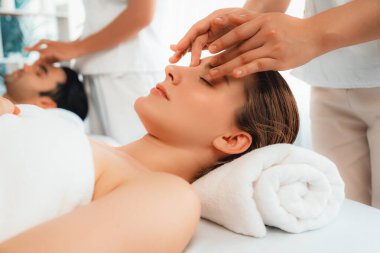 Kafkasyalı çift stres önleyici kafa masajının keyfini çıkarıyor ve lüks otellerde ya da otel spa salonlarında gündüz kaplıcalarında yüz güzelliği eğlencelerini şımartıyor. Sessiz.