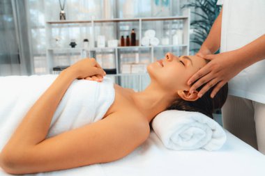 Kafkasyalı kadın stres önleyici kafa masajından ve lüks tatil beldesi ya da otel spa salonundaki modern ışık ortamında yüz güzelliği eğlencelerini şımartmaktan hoşlanıyor. Sessiz.