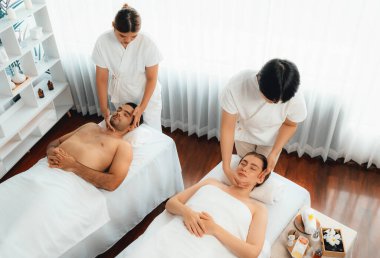 Kafkasyalı çift stres önleyici kafa masajının keyfini çıkarıyor ve lüks otellerde ya da otel spa salonlarında gündüz kaplıcalarında yüz güzelliği eğlencelerini şımartıyor. Sessiz.