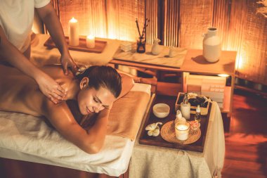 Beyaz kadın müşteri stres önleyici spa masajının keyfini çıkarıyor ve lüks otel ya da otelde sıcak mum ışığında güzellik teniyle eğleniyor. Sessiz.