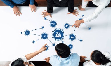 Bir grup profesyonel, dijital medya bağlantıları ve ağ oluşturma stratejisi, takım çalışması ve etkileşimini ön plana çıkaran bir masa etrafında işbirliği yapıyor. Dostluk