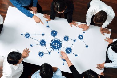 Modern bir iş yerinde bağlantı ve stratejik planlamayı gösteren ağ grafiklerini araştıran çeşitli profesyonellerden oluşan bir grup. Dostluk