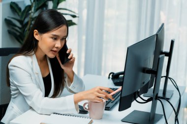 Çalışan Asyalı genç iş kadını müşteriyi arıyor. Kanal satış hedefleri için sosyal web sitesinde analiz etmek üzere çevrimiçi pazarlama stratejisi reklamları sunuyor. Taktik.