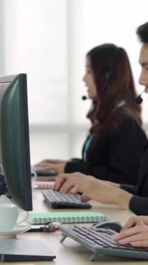 Ofiste çalışan kulaklık takan işadamları uzak müşteri ya da meslektaşlarını desteklemek için çalışıyorlar. Arama merkezi, tele pazarlama, müşteri destek acentesi telefon görüşmesinde hizmet sunar.