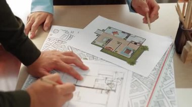 Mimari ekipmanlarla toplantı masasında ev tasarımı üzerine profesyonel mühendis ekibi tartışması ve modern ofiste bina planı dağılımı. Eline odaklan. - Yakın çekim. Tanımlama.