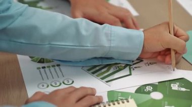 Mükemmel iş adamları, yeşil enerji grafiği kullanımı olan karmaşık bir masada eko ev projesini tartışıyor alternatif enerjiyi seçiyor ya da analiz ediyor, karbonu azaltıp dünyayı kurtarıyor. Eline odaklan. Tanımlama.