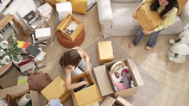 Kızlar oturma odasında birlikte yardım ederken yeni eve taşınmaya bayılırlar. Diğeri kitabı seçip sevgilisine gönderirken birkaç lezbiyen nezaret kutusunun en üst görüntüsü. Yer değiştirme konsepti. Myrmidon.